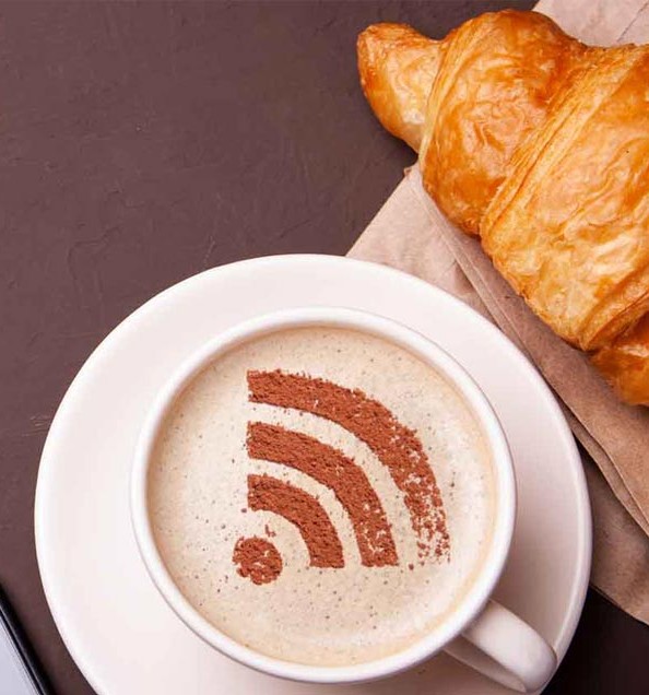 6067823 Mug of coffee with WiFi sign on the foam. Free access point to the Internet WiFi. I like coffee break with croissant
