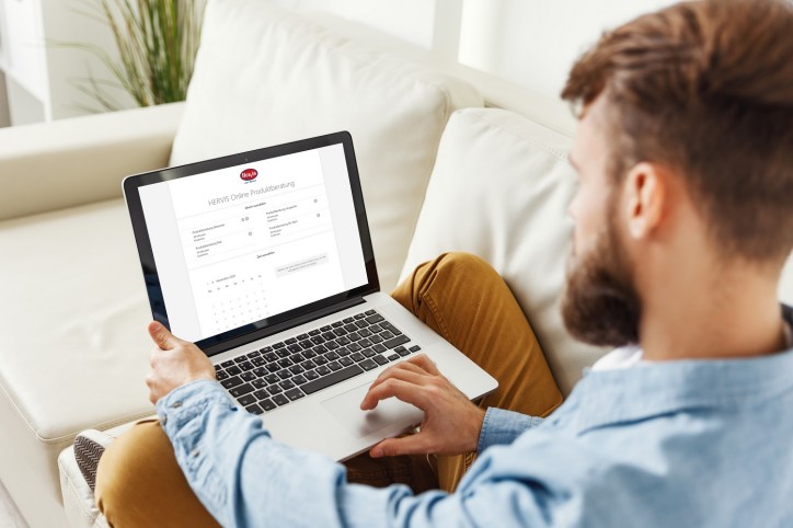 Modern  male sitting on couch and making video call to man financial consultant at home