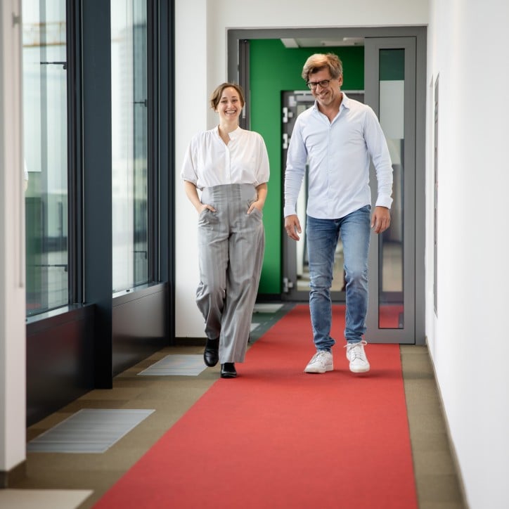 Hub B Opening Kollegen gehend über roten Teppich